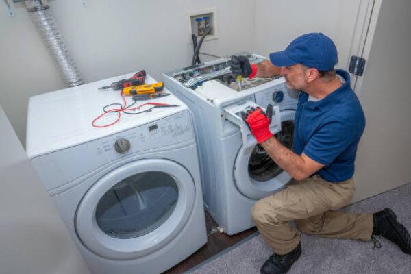 Washer and dryer being serviced by certified repairman from Unique Repair Services