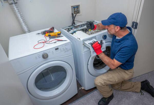 Washer and dryer being serviced by certified repairman from Unique Repair Services