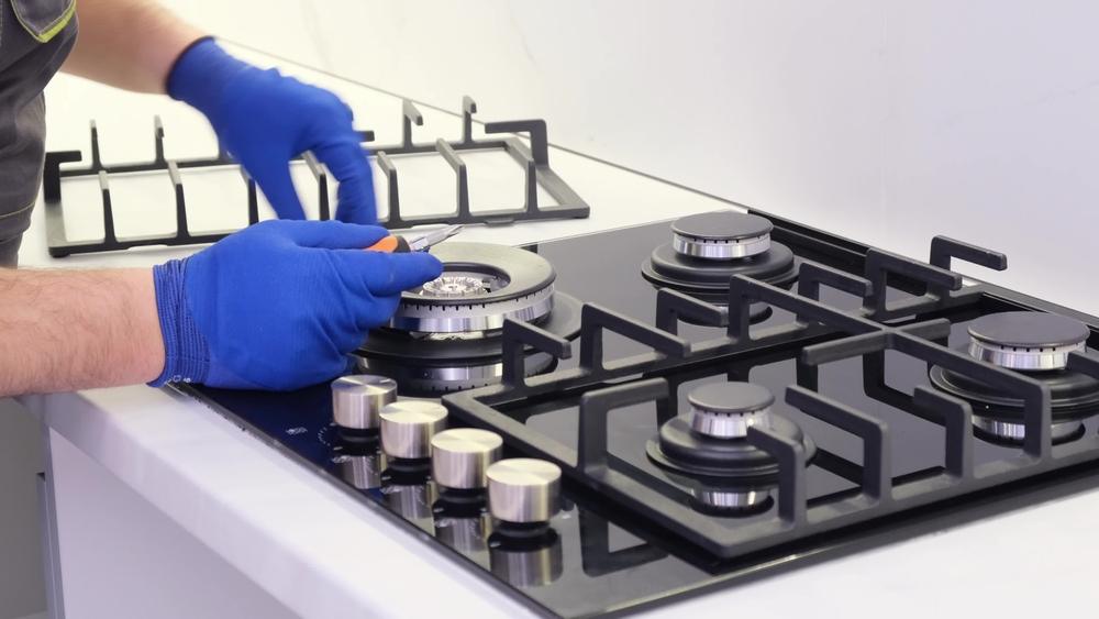 Dacor appliance repair in Des Plaines showing a gas cooktop burner being adjusted during a professional in-home service.