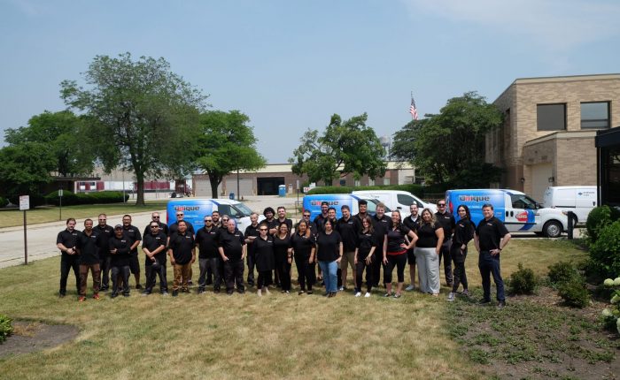 Group photo of Unique Repair Services employees standing together, showcasing a diverse and professional appliance repair team.