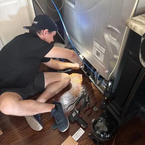 Unique Repair technician replacing a refrigerator compressor